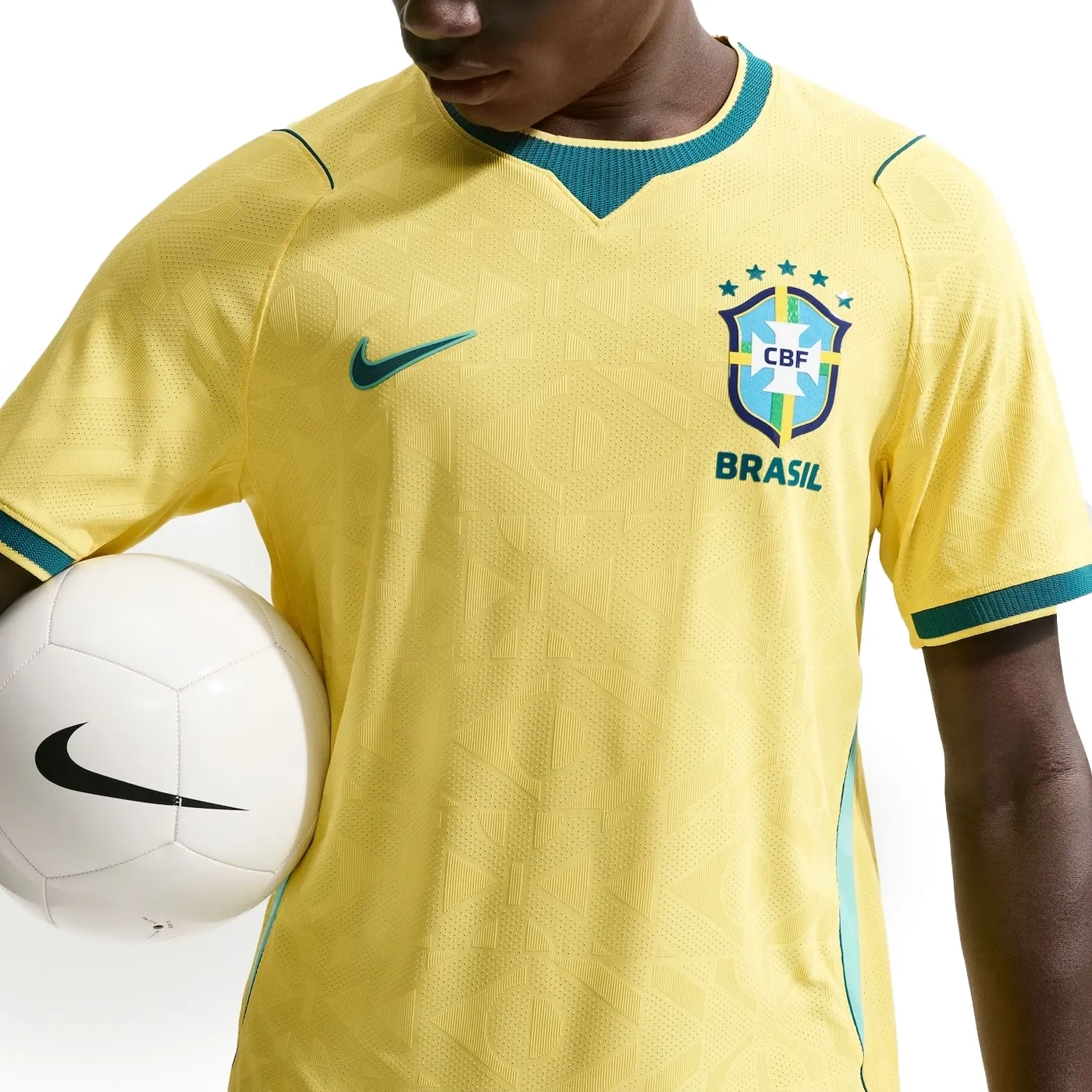 Detalhe frontal da camisa Nike amarela com brasão da seleção brasileira